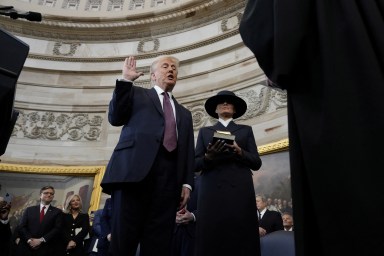 Donald Trump is sworn in as the 47th president of the United States by Chief Justice John Roberts as Melania Trump holds the Bible during the 60th Presidential Inauguration in the Rotunda of the U.S. Capitol in Washington, Monday, Jan. 20, 2025.