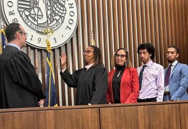 (From L-R): Deputy Chief Administrative Judge for the New York City Courts Adam Silvera swears in Judge Norma Jennings, accompanied by her wife, Judge Juliet Howard, and two sons, Nicholas and Jordan.