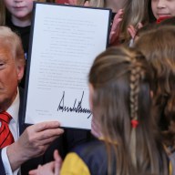 U.S. President Donald Trump holds up a signed executive order banning transgender girls and women from participating in women's sports, in the East Room at the White House in Washington, U.S., February 5, 2025.