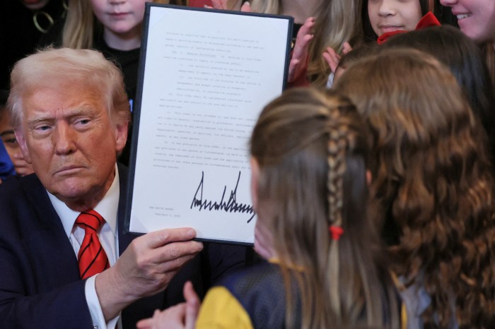 U.S. President Donald Trump holds up a signed executive order banning transgender girls and women from participating in women's sports, in the East Room at the White House in Washington, U.S., February 5, 2025.