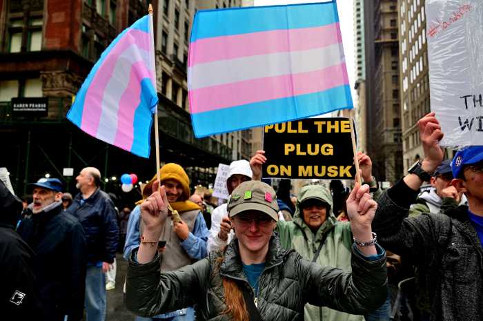 A marcher holds Trans Flags during a "Hands Off" protest in New York City in April.