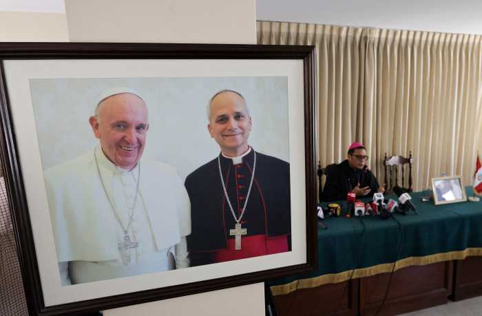A picture depicting the late Pope Francis and Pope Leo XIV prior to his election is displayed as Bishop Edinson Edgardo Farfan Cordova speaks during a press conference, following the election of Pope Leo XIV, in Chiclayo, Peru, May 9, 2025.