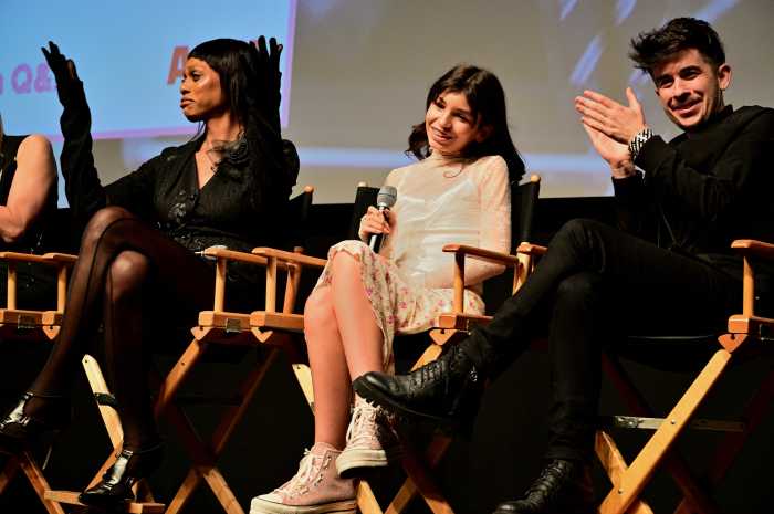 Laverne Cox (left) and Chase Strangio (right) cheer Mila's (center) comments.