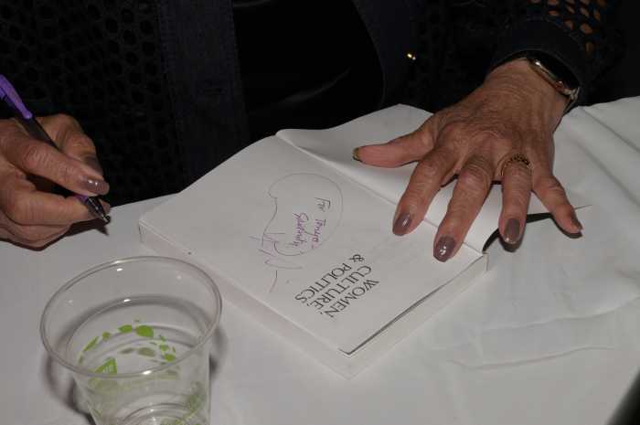 Angela Davis signs a copy of her book, "Women, Culture, & Politics."