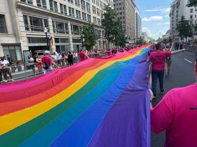 The late Gilbert Baker's long Rainbow Flag stretches through the streets of Washington.