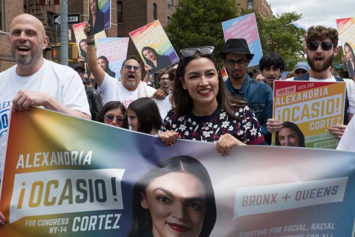 Congressmember Alexandria Ocasio-Cortez holds her contingent's banner at Queens Pride.