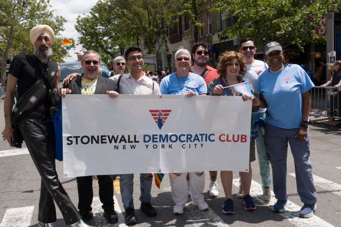 The Stonewall Democratic Club of New York City gathers around the club's banner.
