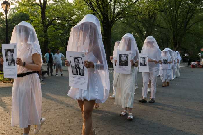 Human Beings hold photos of people who died in the Pulse shooting nine years ago.