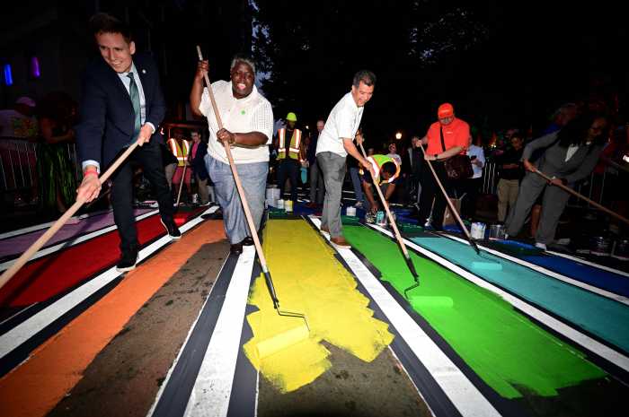 Out gay Councilmember Erik Bottcher (left) helps to paint the crosswalk.