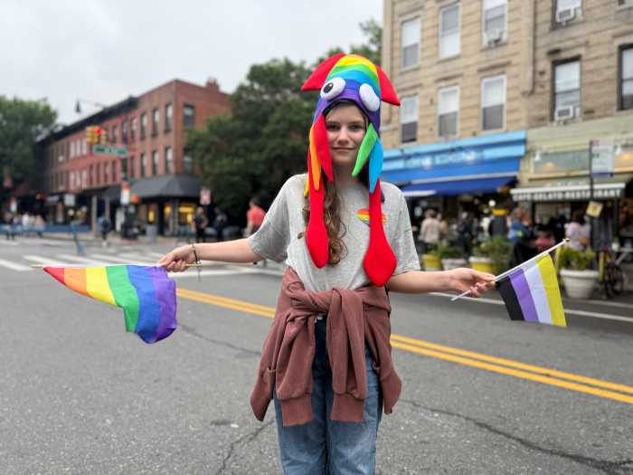 Shura holds a Rainbow Flag and a Non-Binary Flag.