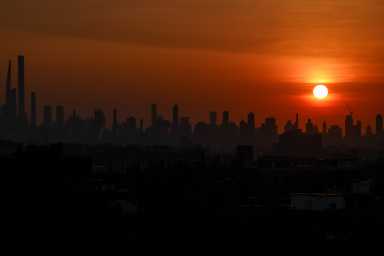 The sun sets behind the Manhattan skyline in New York City, U.S., June 23, 2025.
