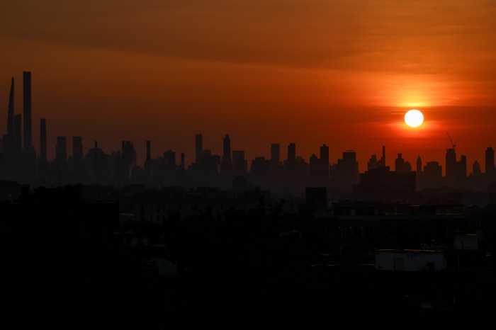 The sun sets behind the Manhattan skyline in New York City, U.S., June 23, 2025.