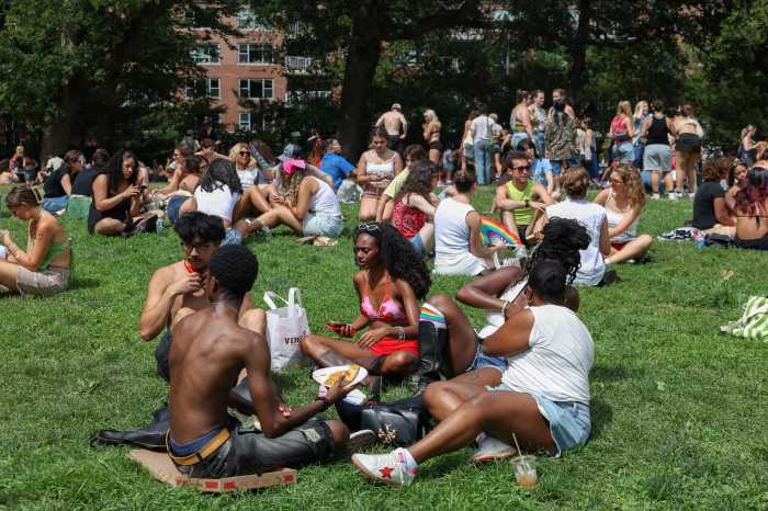 People sit on the lawn of Washington Square Park after the 2025 NYC Pride March in New York City, June 29, 2025.