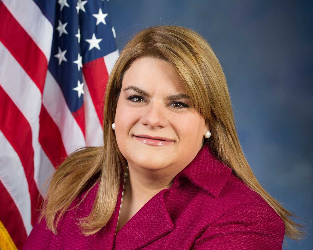 Puerto Rico Gov. Jenniffer González-Colón looks at the camera during a portrait with the American Flag in the background.