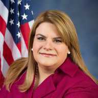 Puerto Rico Gov. Jenniffer González-Colón looks at the camera during a portrait with the American Flag in the background.