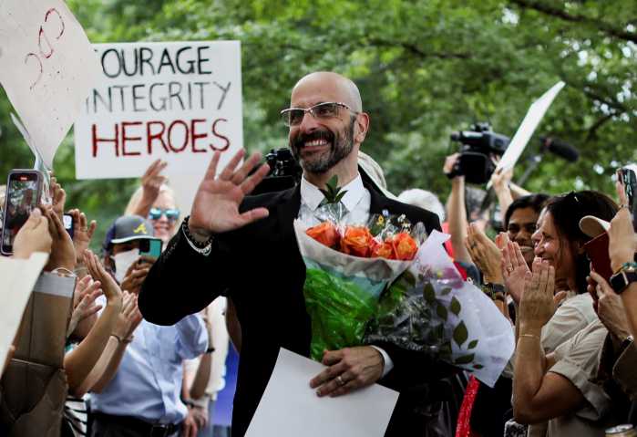 Former National Center for Immunization and Respiratory Diseases Director Demetre Daskalakis waves as he carries flowers while people applaud him during a protest, a day after several top officials — including Daskalakis — resigned, in Atlanta, Georgia, U.S.
