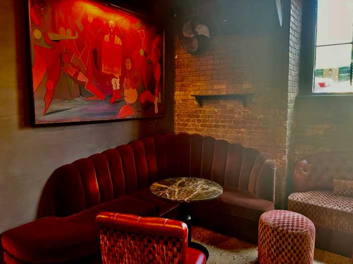 Hues of red complement the seating area, accompanied by artwork on the wall.
