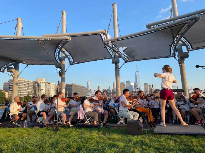 David Bloom conducting the Queer Urban Orchestra at the "Sunset on the Hudson" concert in the summer of 2023.