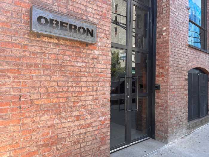 The exterior of Oberon, with a brick wall and a sign that reads "OBERON."