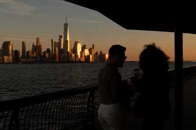 People observe lower Manhattan at sunset in New York City, U.S., October 18, 2025.