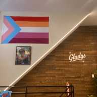 A Lesbian and Transgender Flag Hangs Above a Portrait of Marsha P. Johnson.