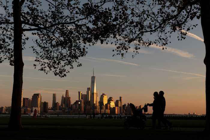 People observe lower Manhattan at sunset in New York City, U.S., October 18, 2025.