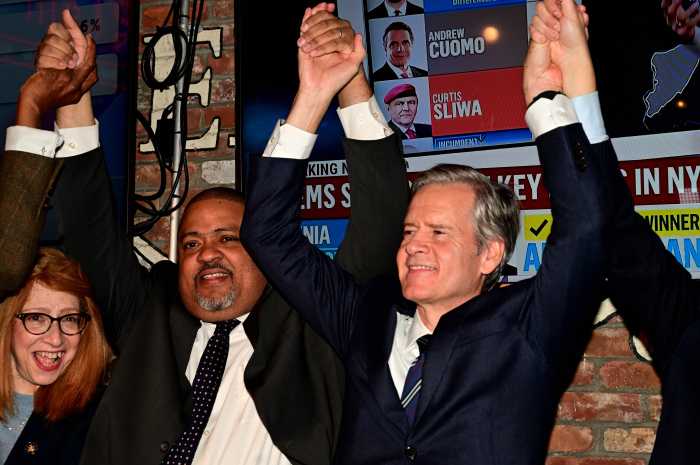 Assemblymember Linda Rosenthal, Manhattan District Attorney Alvin Bragg, and Manhattan Borough President-Elect Brad Hoylman-Sigal join hands on election night.