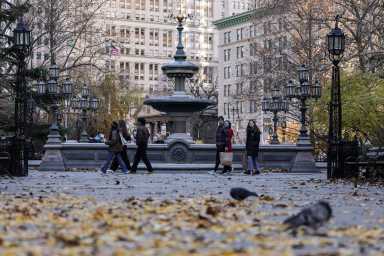 People walk past City Hall Park in New York City, U.S., November 28, 2025.