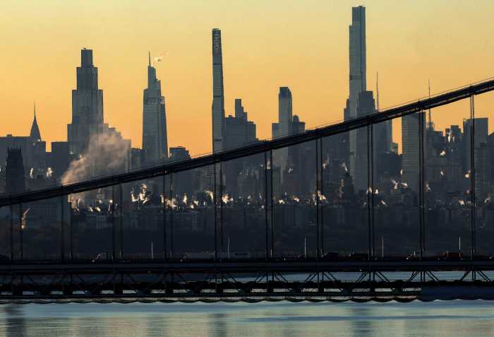 Steam rises from buildings as the sun rises over Manhattan beyond the George Washington Bridge and the Hudson River, as a blast of Arctic air gripped much of the central and eastern portions of the U.S, in New York City, U.S., December 9, 2025.