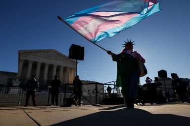 A demonstrator wearing a Statue of Liberty crown waves a Transgender Flag outside the U.S. Supreme Court, as the justices heard oral arguments in two cases concerning efforts to enforce Republican-backed state laws banning transgender athletes from female sports teams at public schools, in Washington, D.C., U.S., January 13, 2026.
