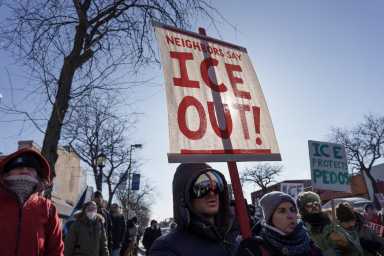 Demonstrators carry signs condemning Immigration and Customs Enforcement (ICE) near the site where a man identified as Alex Pretti was fatally shot by federal agents trying to detain him, in Minneapolis, Minnesota, U.S., January 24, 2026. REUTERS/Tim Evans
