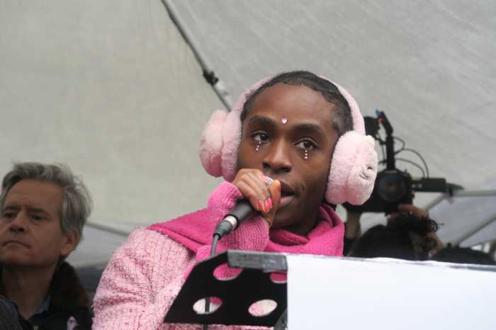 Majé Zenith Louverture speaks on stage.