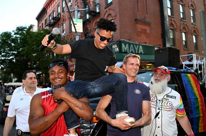 LGBTQIA+ Caucus member Chi Ossé, second from left, carries fellow caucus member Crystal Hudson, with Erik Bottcher at Brooklyn Pride in 2024. Hudson and Bottcher previously served as co-chairs.