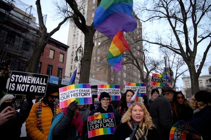 Rainbow Flags tower above speakers at Christopher Park.