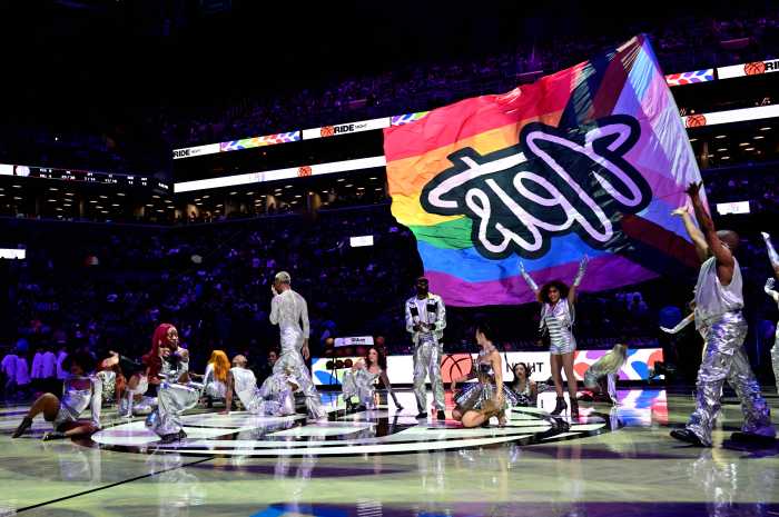 A customized Brooklyn Nets Progress Pride Flag towers over the performers during the halftime show.