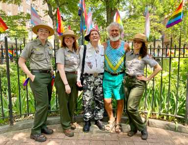 Steven Love Menendez (second from right) with Randy Wicker (center) and park rangers in front of the flagpole at the Stonewall National Monument in 2022 — during the Biden administration.