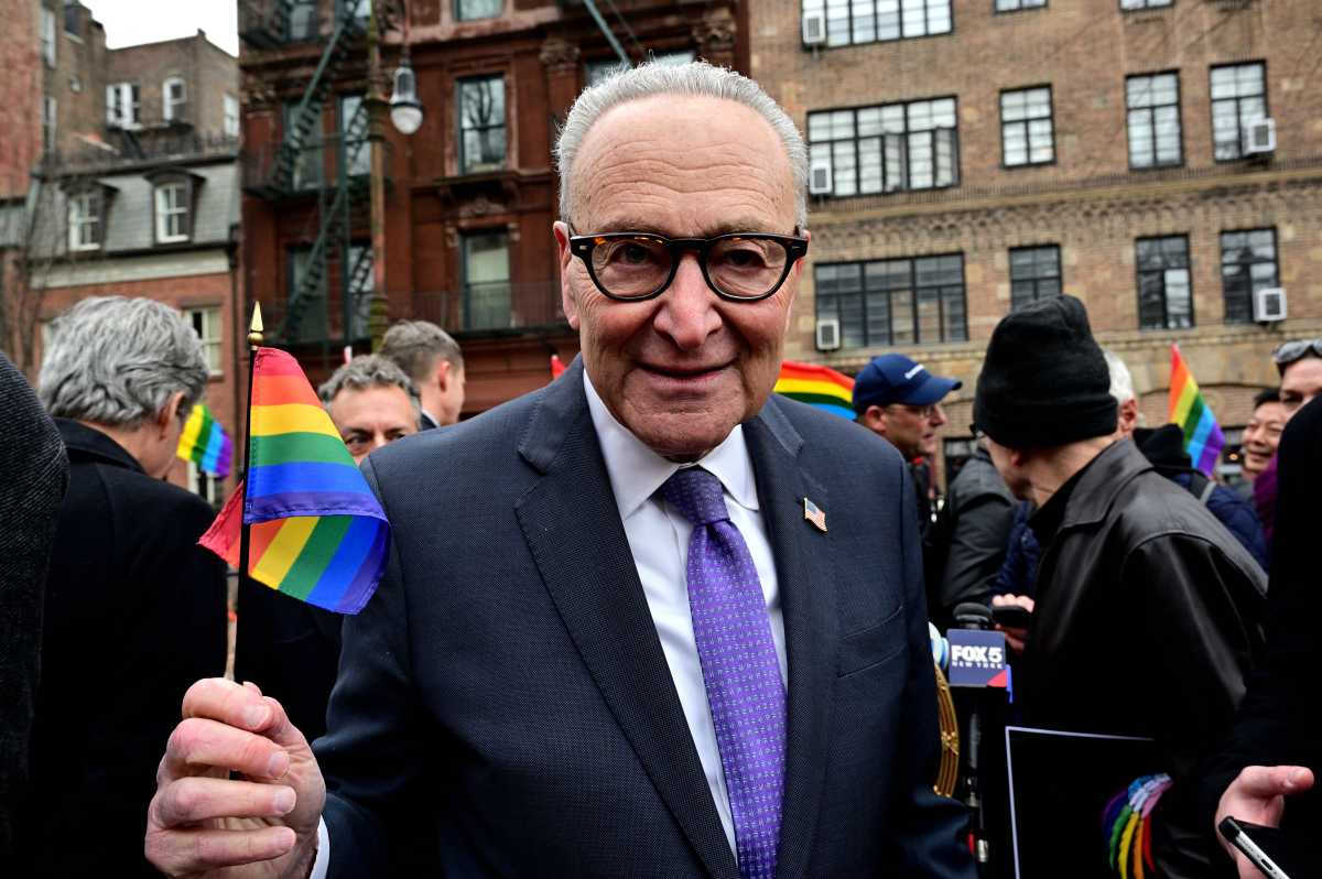 Senator Chuck Schumer waves a Rainbow Flag after announcing new legislation at the Stonewall National Monument on Feb. 15