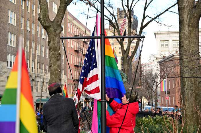 Activists Jay W. Walker (left) and Josh Tjaden install the Rainbow Flag at the Stonewall National Monument.