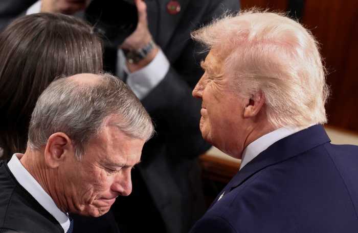 U.S. President Donald Trump, next to Supreme Court Chief Justice John Roberts, arrives to deliver the State of the Union address to a joint session of Congress in the House Chamber at the U.S. Capitol in Washington, D.C., U.S., February 24, 2026.  