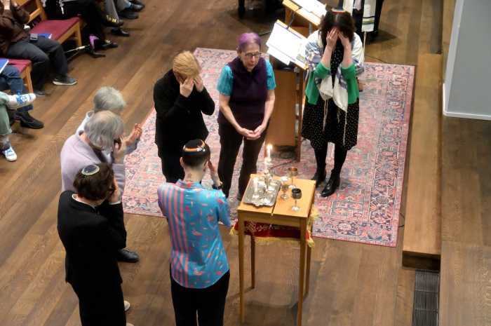 transgender and non-binary individuals, along with their allies, light candles.