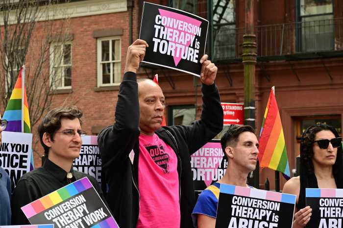 Jay W. Walker holds a sign describing conversion therapy as torture.