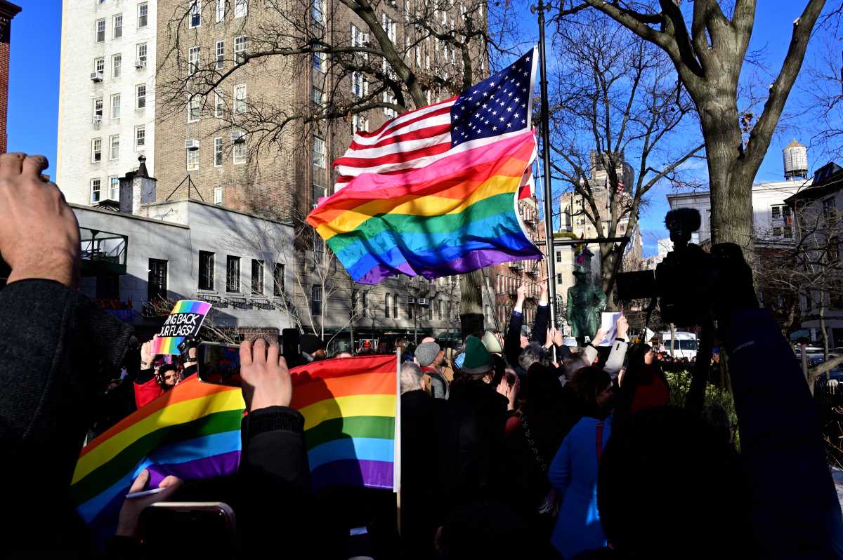 The Rainbow Flag and American Flag blow in the wind during a flag-raising ceremony at the Stonewall National Monument on Feb. 12.
