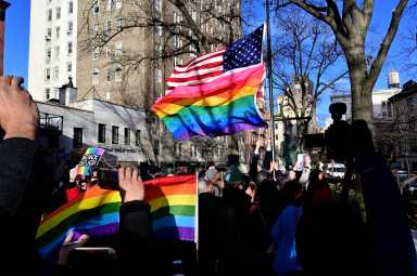 The Rainbow Flag and American Flag blow in the wind during a flag-raising ceremony at the Stonewall National Monument on Feb. 12.