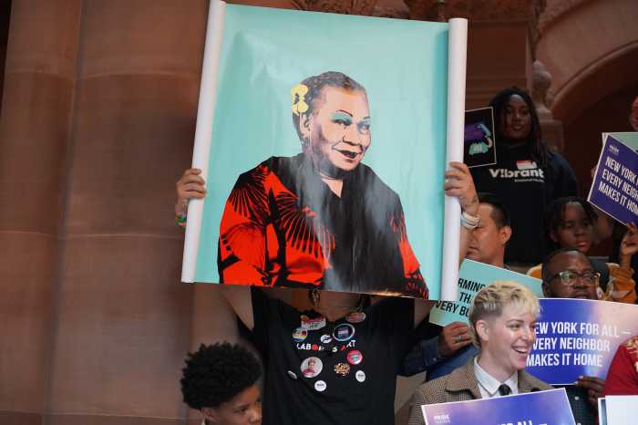 Advocates hold up a painting of the late Lorena Borjas.