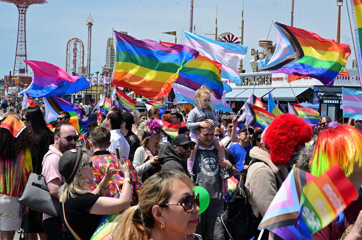 Community members march along the boardwalk at Brighton Beach Pride.