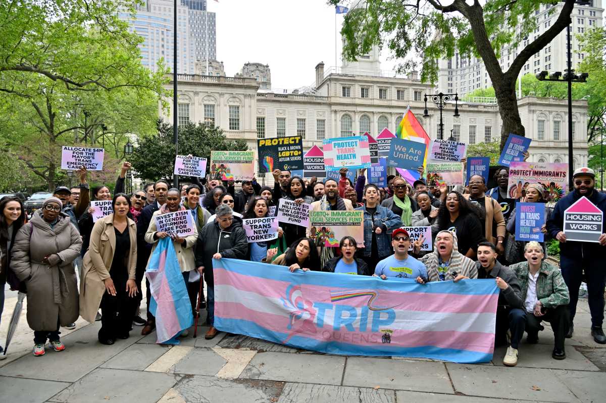 Advocates huddle in front of City Hall to rally for increased funding for trans initiatives in the city budget.