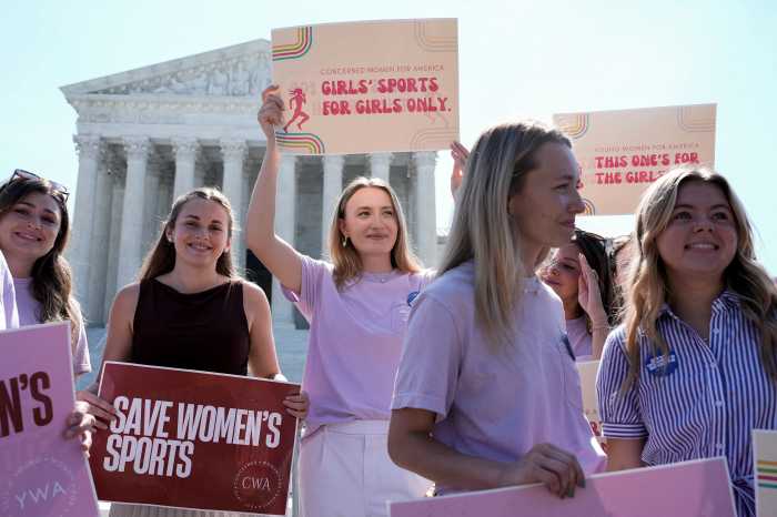 Women hold placards as they celebrate the U.S. Supreme Court's final rulings of its nine-month term, including a decision that cleared the way for states to impose restrictions on transgender student athletes, upholding laws in West Virginia and Idaho banning them from female sports teams, in Washington, D.C., U.S., June 30, 2026. 