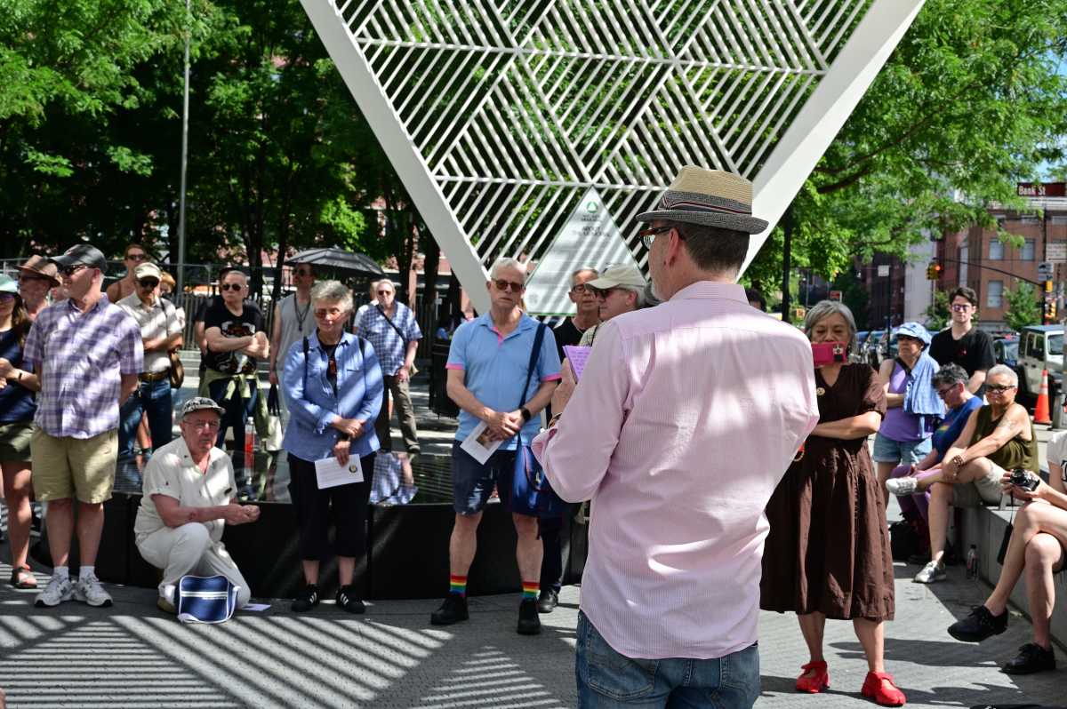 Community members look on while David France speaks at a gathering to remember Iris Long.