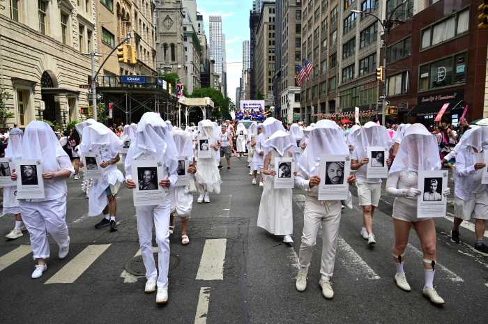 Gays Against Guns' Human Beings hold placards honoring slain community members.