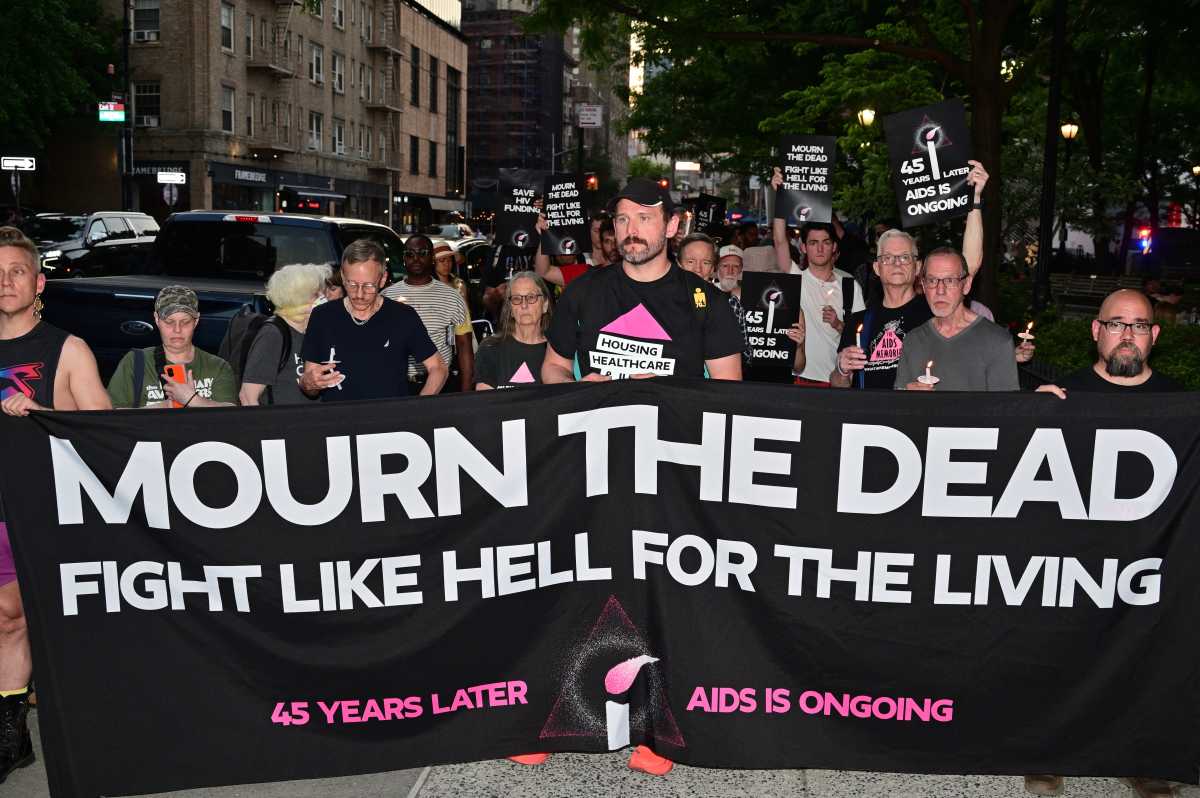 Community members carry a banner calling to mourn the dead and fight for the living.